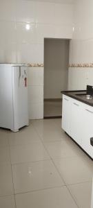 a kitchen with a white refrigerator in a room at Chalés Pôr Do Sol in Alto Caparao