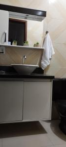 a bathroom counter with a sink and a mirror at Chalés Pôr Do Sol in Alto Caparao