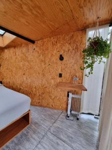 a room with a wooden wall with a table at Glamping Pinochueco in Huasca de Ocampo