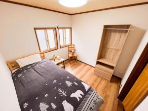 a bedroom with a bed with a black comforter at KONAYUKI in Myoko