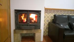 a fireplace in a living room next to a couch at Casa das Neves in Ponte de Lima