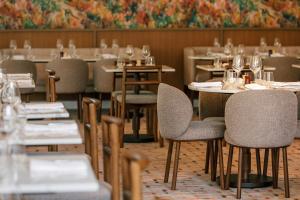 um restaurante com mesas e cadeiras com copos de vinho em Amora Hotel Brisbane em Brisbane