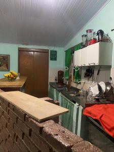 uma cozinha com uma mesa e uma bancada em Pousada Matriz em São Thomé das Letras mais 46 fotografias