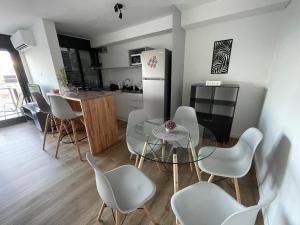 cocina con mesa, sillas y nevera en UruSamKa Apartamento 2 dormitorios en Centro MoNteVidEo, en Montevideo