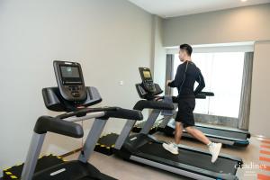 a woman running on a treadmill in a gym at Citadines Keqiao Shaoxing in Shaoxing