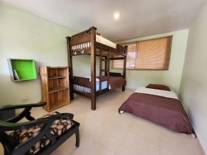 a bedroom with two bunk beds and a flat screen tv at Hostal Minkalab in Santa Rosa de Cabal