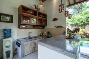 a kitchen with a sink and a counter top at Villa Alam Surya Ubud in Ubud