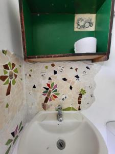 a white sink in a bathroom with a tiled wall at Hostal Minkalab in Santa Rosa de Cabal