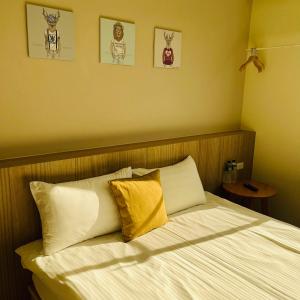 台東市的住宿－古栗Chestnut Guest House-可包棟民宿，一间卧室配有带白色床单和黄色枕头的床。