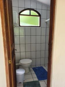 a small bathroom with a toilet and a window at Casa da Neia in Paraty