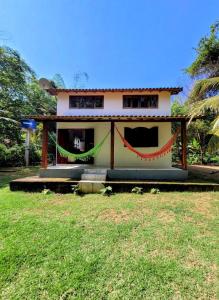 uma casa com bandeiras vermelhas e verdes à sua frente em Casa da Neia em Paraty