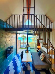 ein Wohnzimmer mit einer Treppe, einem Sofa und einem Tisch in der Unterkunft Yaho Beach House in Jeju-do