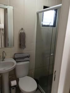 uma casa de banho com um chuveiro, um WC e um lavatório. em Casinha na serra para até 4 pessoas em Nova Petrópolis