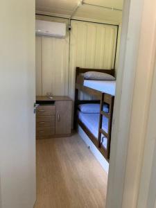 Mały pokój z 2 łóżkami piętrowymi i biurkiem w obiekcie Casinha na serra para até 4 pessoas w mieście Nova Petrópolis