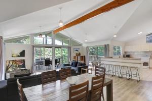 een keuken en een woonkamer met een tafel en stoelen bij Amaroo House in Point Lookout