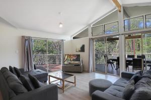 a living room with two couches and a table at Amaroo House in Point Lookout
