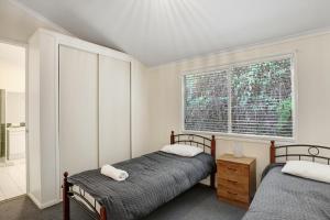 2 bedden in een slaapkamer met een raam bij Amaroo House in Point Lookout