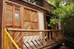 a wooden balcony of a house with a window at Bio Coliving Tayrona, Eco Retreat for You or Your group with Fast, Reliable WiFi & Power in Nature in Santa Marta