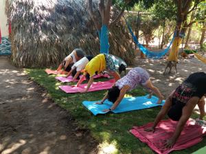 un grupo de personas haciendo yoga en la hierba en Glamping Bio Coliving Tayrona en Santa Marta