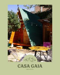 una casa con tetto verde e tavolo e sedie di Hostal Casa Gaia a San Cristóbal de Las Casas