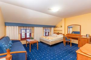 シュクラルスカ・ポレンバにあるFantazjaのリビングルーム(青いソファ、ベッド付)