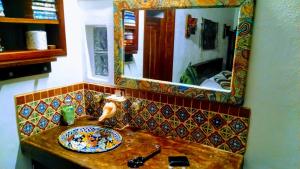 a bathroom sink with a mirror and a plate on it at Mayan Beach Garden in El Placer