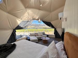 a room with a bed and a couch in a tent at Glamping Dome - Rosé in Cromwell