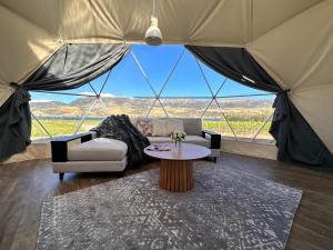 a living room with a large tent with a table at Glamping Dome - Rosé in Cromwell