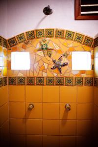 a bathroom with two lights and a tiled wall at Mayan Beach Garden in El Placer