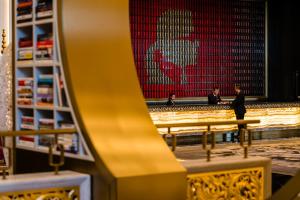 a group of people standing in front of a large painting at THE KARL LAGERFELD in Macau