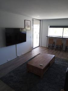 uma sala de estar com uma mesa de centro e uma televisão de ecrã plano em Maroochy Sands Holiday Apartments em Maroochydore