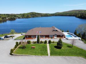 - une vue aérienne sur une maison avec un lac dans l'établissement Auberge Du Lac Malcom, à Sayabec