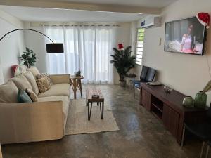 a living room with a couch and a flat screen tv at Villa Susanna 3 bedroom 2 bathroom house sleeps 6Plus in Willemstad