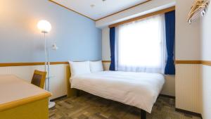 a small room with a bed and a window at Toyoko Inn Nagoya Sakae in Nagoya