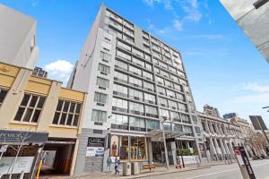 a tall white building on a city street at Central City Living Murray Street Studio in Perth