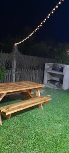 a wooden picnic table in the grass at night at B&Z Departamentos in Federación