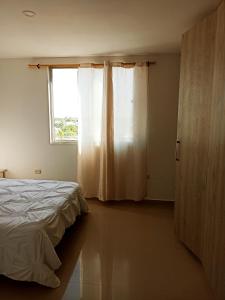 um quarto com uma cama e uma janela em Hermoso apartamento frente al mar em Ríohacha