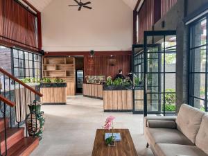 a lobby of a restaurant with a person sitting at a counter at Kanhara Villas Ubud by Pramana Villas in Ubud