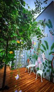 two chairs and a table on a deck with a mural at เรินนายหัว by KOYAD 