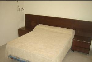 un letto con testiera in legno in una camera da letto di Departamentos del Sol a Resistencia