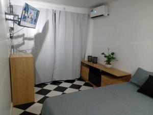 1 dormitorio con 1 cama y escritorio con TV en Departamento monoambiente Belgrano R en Buenos Aires