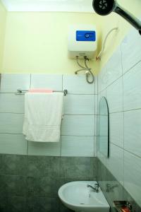 a bathroom with a sink and a mirror and a towel at St. Patrick’s Forest House in Entebbe