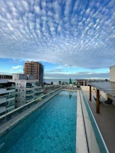 une piscine sur le toit d'un immeuble dans l'établissement Apartamento Pérola - Zona Sul de Ilhéus - 200 m da praia, à Ilhéus