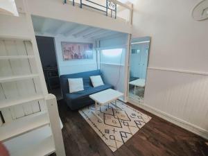 a living room with a blue couch and a bunk bed at appartement parc des expositions/tour eiffel in Paris