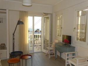 salon ze stołem i krzesłami oraz balkonem w obiekcie Anassa Suites w mieście Naksos