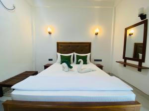 una camera da letto con un letto con due animali di peluche sopra di Perfect Hideout a Dambulla