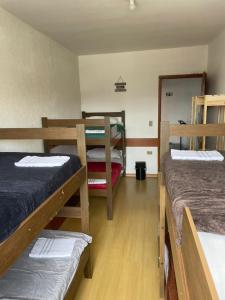 a room with three bunk beds and a mirror at Hostel Salus in Barueri