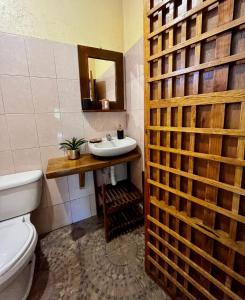 La salle de bains est pourvue d'un lavabo, de toilettes et d'un miroir. dans l'établissement Casa Guiba 1 puerto escondido, à Puerto Escondido
