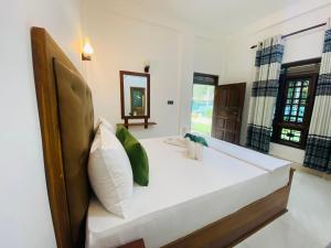 um quarto com uma grande cama branca num quarto em Perfect Hideout em Dambulla