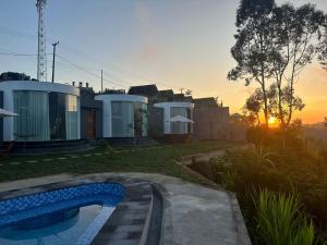 a house with a swimming pool in front of a sunset at Pinggan Cliff in Baturaja